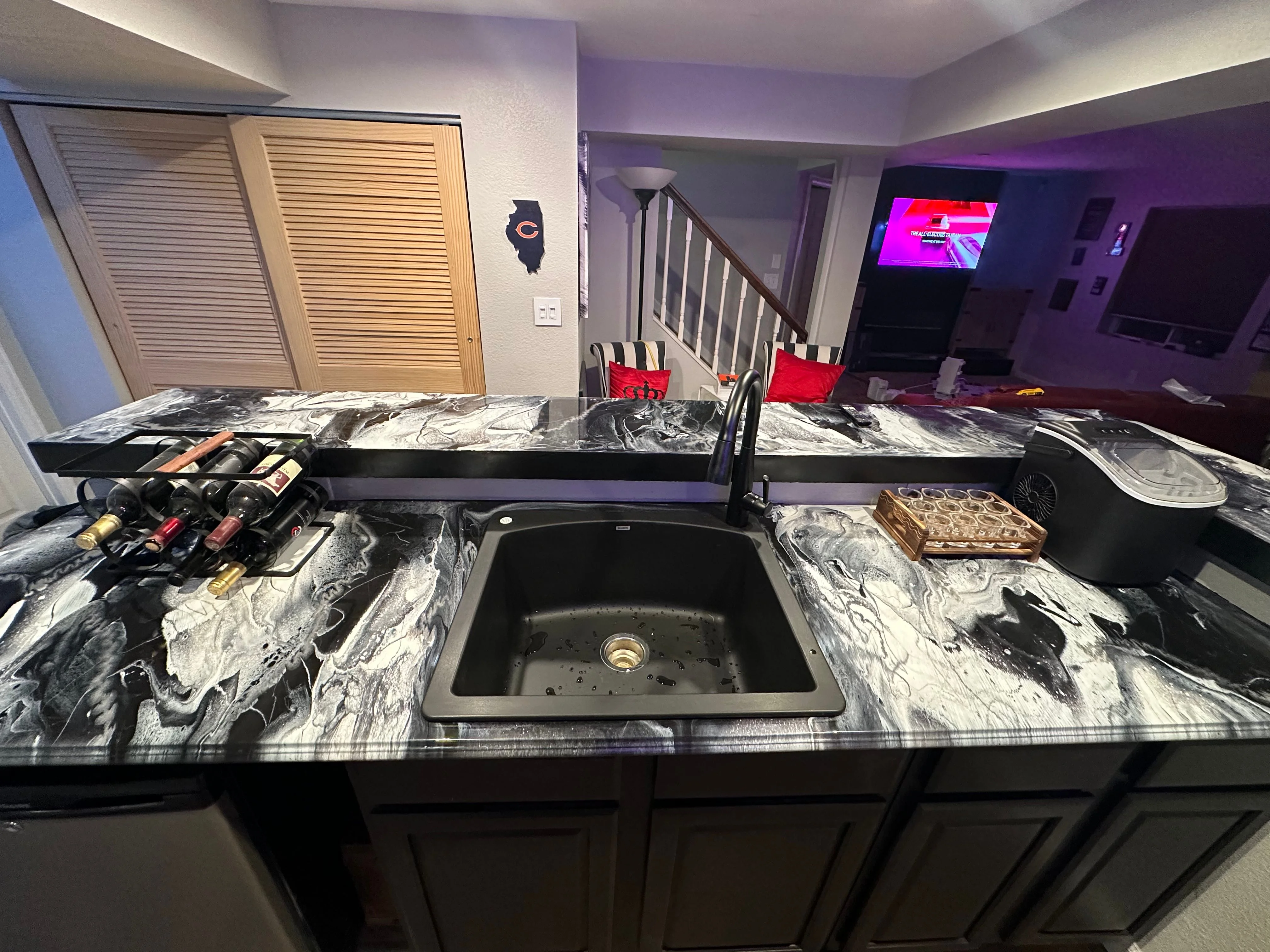 A finished custom concrete countertop installed in a Colorado Springs kitchen, showing a smooth matte surface with an integrated sink and custom edge detail. The countertop runs along white shaker cabinets with natural light coming through a window above the sink.